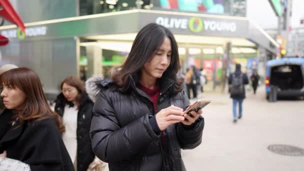 Filmik Koreańczykiem Trzydziestce Operującym Smartfonem Mroźną Zimę Myeong Dong Seul — Wideo stockowe