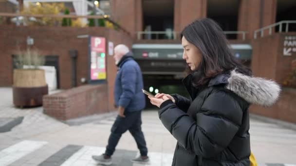 韩国首尔明东寒冷的冬天 一个30多岁的韩国男人在使用智能手机的慢镜头 — 图库视频影像