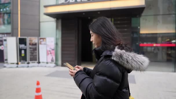 韩国首尔明东寒冷的冬天 一个30多岁的韩国男人在使用智能手机的慢镜头 — 图库视频影像