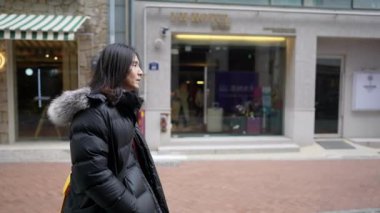 Myeong-dong, Seul, Güney Kore 'nin ana caddesinde 30' lu yaşlarında yürüyen Koreli bir adamın yavaş çekim videosu.