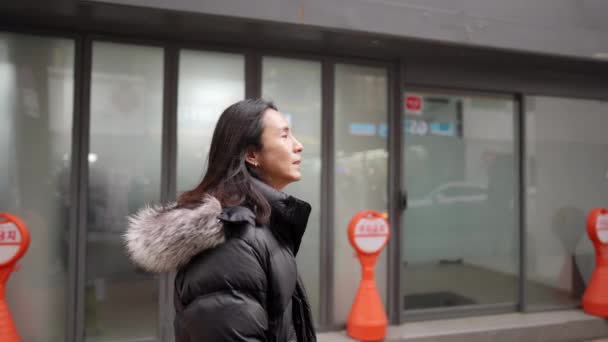 寒い冬に韓国の明洞のメインストリートを歩いている30代の韓国人男性のスローモーションビデオ — ストック動画