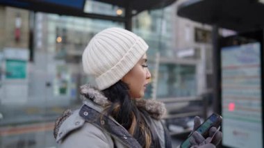 Güney Kore, Seul sokaklarında otobüs durağında 20 'li yaşlarında bir Filipinli kadın otobüs bekliyor.