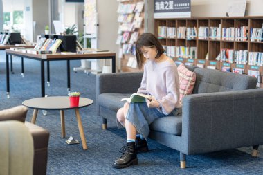 Tayvan 'ın Taipei şehrindeki Wenshan Bölgesi' nde güzel bir kütüphanede zaman geçiren 20 yaşındaki Tayvanlı bir kızın yavaş çekim videosu.