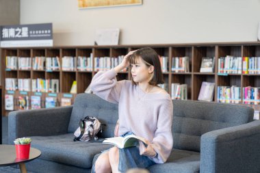 Tayvan 'ın Taipei şehrindeki Wenshan Bölgesi' nde güzel bir kütüphanede zaman geçiren 20 yaşındaki Tayvanlı bir kızın yavaş çekim videosu.