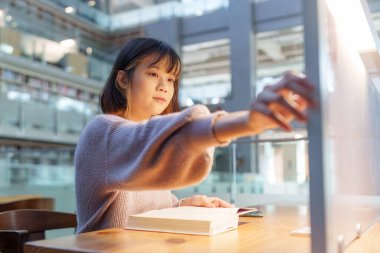 Tayvan 'ın Taipei şehrindeki Wenshan Bölgesi' nde güzel bir kütüphanede zaman geçiren 20 yaşındaki Tayvanlı bir kızın yavaş çekim videosu.
