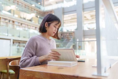 Tayvan 'ın Taipei şehrindeki Wenshan Bölgesi' nde güzel bir kütüphanede zaman geçiren 20 yaşındaki Tayvanlı bir kızın yavaş çekim videosu.