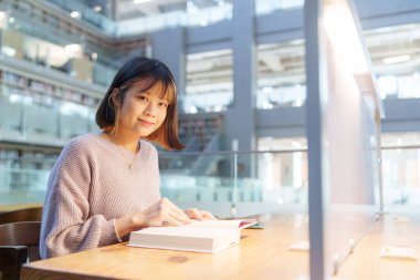 Tayvan 'ın Taipei şehrindeki Wenshan Bölgesi' nde güzel bir kütüphanede zaman geçiren 20 yaşındaki Tayvanlı bir kızın yavaş çekim videosu.