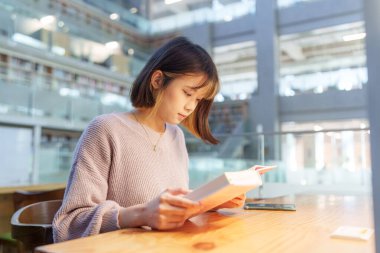 Tayvan 'ın Taipei şehrindeki Wenshan Bölgesi' nde güzel bir kütüphanede zaman geçiren 20 yaşındaki Tayvanlı bir kızın yavaş çekim videosu.