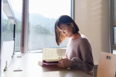 Tayvan 'ın Taipei şehrindeki Wenshan Bölgesi' nde güzel bir kütüphanede zaman geçiren 20 yaşındaki Tayvanlı bir kızın yavaş çekim videosu.