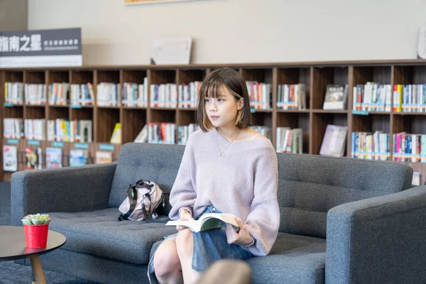 Slow-motion video of a 20-year-old Taiwanese female college student spending time in a beautiful library at a university in Wenshan District, Taipei City, Taiwan
