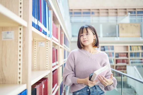 Slow-motion video of a 20-year-old Taiwanese female college student spending time in a beautiful library at a university in Wenshan District, Taipei City, Taiwan