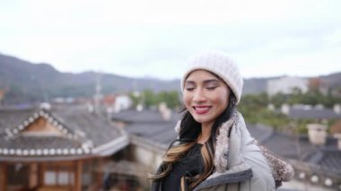 20 'li yaşlarda Filipinli bir kadın Güney Kore, Seul' deki Bukchon Hanok Köyü 'nde geleneksel kasaba manzarasına bakıyor.
