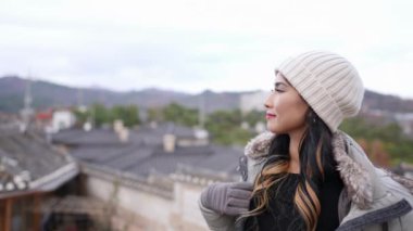 20 'li yaşlarda Filipinli bir kadın Güney Kore, Seul' deki Bukchon Hanok Köyü 'nde geleneksel kasaba manzarasına bakıyor.