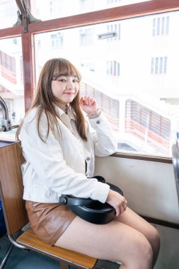 Hong Kong 'da tramvaya binen 20' li yaşlarda Çinli bir kadın.