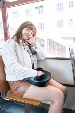 Hong Kong 'da tramvaya binen 20' li yaşlarda Çinli bir kadın.