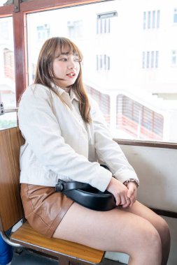 Hong Kong 'da tramvaya binen 20' li yaşlarda Çinli bir kadın.