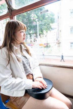 Hong Kong 'da tramvaya binen 20' li yaşlarda Çinli bir kadın.