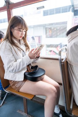 Hong Kong 'da tramvaya binen 20' li yaşlarda Çinli bir kadın.