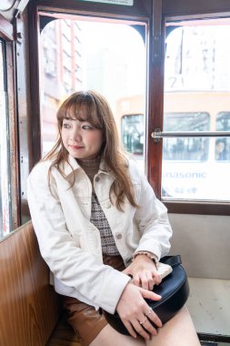 Hong Kong 'da tramvaya binen 20' li yaşlarda Çinli bir kadın.