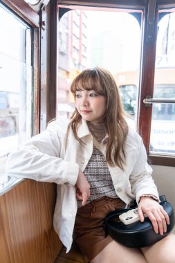 Hong Kong 'da tramvaya binen 20' li yaşlarda Çinli bir kadın.