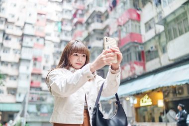 20 'li yaşlarda Çinli bir kadın Hong Kong' da yürüyüş yapıyor.