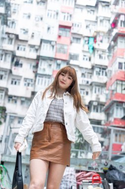 20 'li yaşlarda Çinli bir kadın Hong Kong' da yürüyüş yapıyor.