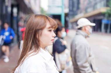 20 'li yaşlarda Çinli bir kadın Hong Kong' da yürüyüş yapıyor.