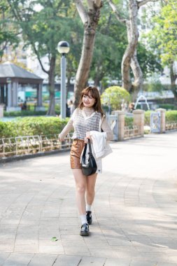 20 'li yaşlarda Çinli bir kadın Hong Kong' da yürüyüş yapıyor.