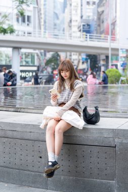 20 'li yaşlarda Çinli bir kadın Hong Kong' da yürüyüş yapıyor.