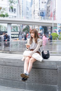 20 'li yaşlarda Çinli bir kadın Hong Kong' da yürüyüş yapıyor.