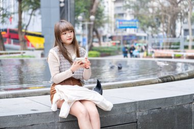 20 'li yaşlarda Çinli bir kadın Hong Kong' da yürüyüş yapıyor.