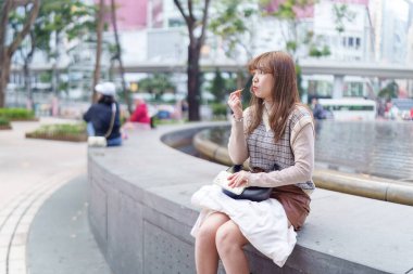 20 'li yaşlarda Çinli bir kadın Hong Kong' da yürüyüş yapıyor.