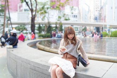 20 'li yaşlarda Çinli bir kadın Hong Kong' da yürüyüş yapıyor.