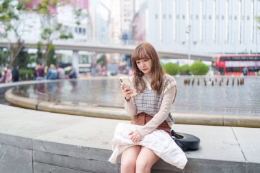 20 'li yaşlarda Çinli bir kadın Hong Kong' da yürüyüş yapıyor.