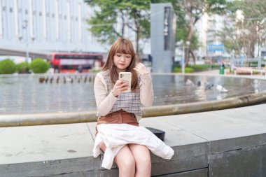 20 'li yaşlarda Çinli bir kadın Hong Kong' da yürüyüş yapıyor.