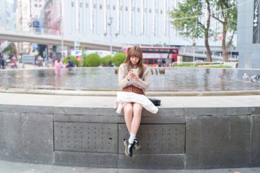 20 'li yaşlarda Çinli bir kadın Hong Kong' da yürüyüş yapıyor.