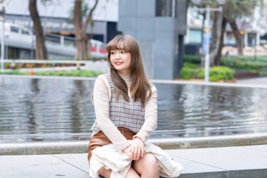 20 'li yaşlarda Çinli bir kadın Hong Kong' da yürüyüş yapıyor.