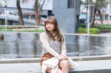 20 'li yaşlarda Çinli bir kadın Hong Kong' da yürüyüş yapıyor.