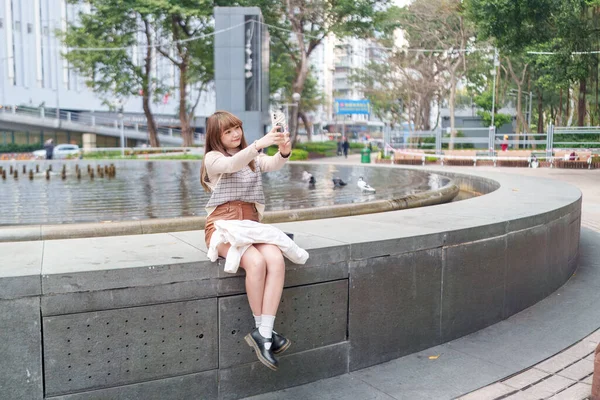 20 'li yaşlarda Çinli bir kadın Hong Kong' da yürüyüş yapıyor.