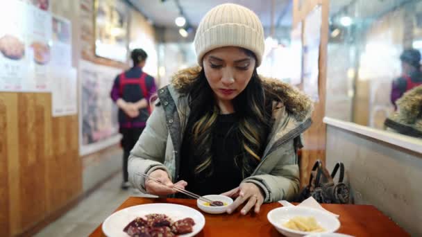 20代のフィリピン人女性が韓国のソウルのレストランで生肝臓を食べる — ストック動画