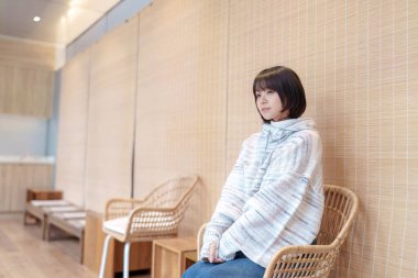  20 'li yaşlarda Çinli bir kadın Hong Kong' da soğuk bir kış günü dinlenme yerinde mola veriyor.