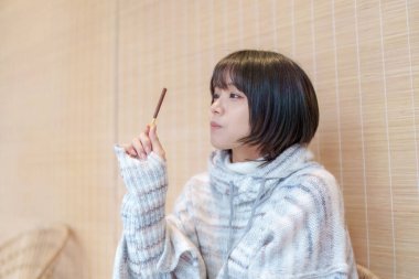  20 'li yaşlarda Çinli bir kadın Hong Kong' da soğuk bir kış günü dinlenme yerinde mola veriyor.