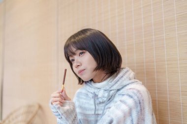  20 'li yaşlarda Çinli bir kadın Hong Kong' da soğuk bir kış günü dinlenme yerinde mola veriyor.