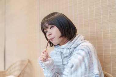  20 'li yaşlarda Çinli bir kadın Hong Kong' da soğuk bir kış günü dinlenme yerinde mola veriyor.