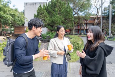 Tayvan 'ın Taipei şehrinde Da' an Bölgesi 'ndeki bir üniversitede konuşan üç üniversite öğrencisi.