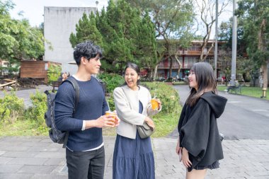 Tayvan 'ın Taipei şehrinde Da' an Bölgesi 'ndeki bir üniversitede konuşan üç üniversite öğrencisi.