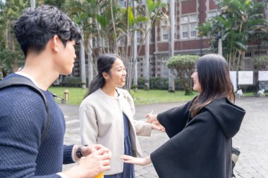Tayvan 'ın Taipei şehrinde Da' an Bölgesi 'ndeki bir üniversitede konuşan üç üniversite öğrencisi.