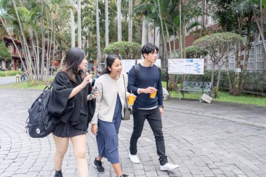 Tayvan 'ın Taipei şehrinde Da' an Bölgesi 'ndeki bir üniversitede konuşan üç üniversite öğrencisi.