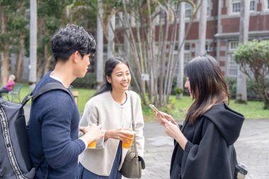 Tayvan 'ın Taipei şehrinde Da' an Bölgesi 'ndeki bir üniversitede konuşan üç üniversite öğrencisi.