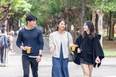 Tayvan 'ın Taipei şehrinde Da' an Bölgesi 'ndeki bir üniversitede konuşan üç üniversite öğrencisi.